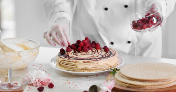Chef Confeiteira decorando um Bolo com Frutas Vermelhas.
Explorando as Diferenças: Padaria e Confeitaria.