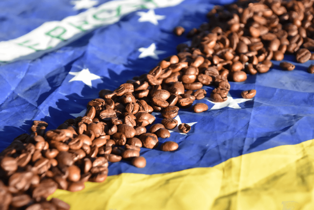 Imagem de grãos de café sobre a bandeira do Brasil. Simbolo da cozinha brasileira, produto brasileiro de alta qualidade, iguaria brasileira de exportação.