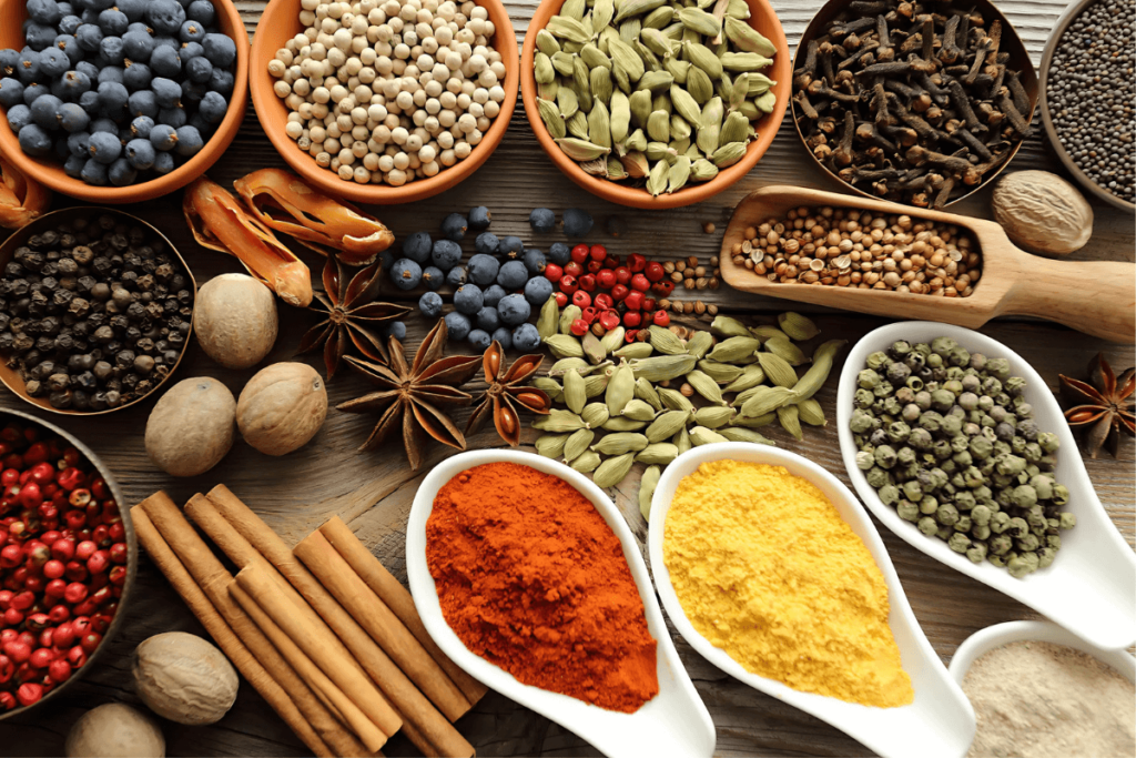 Diversos temperos e especiarias como pimenta, canela, cravo, noz moscada, colorau e cardamomo. Ingredientes da cozinha brasileira, temperos para culinária do Brasil, manjar brasileiro de aromas.