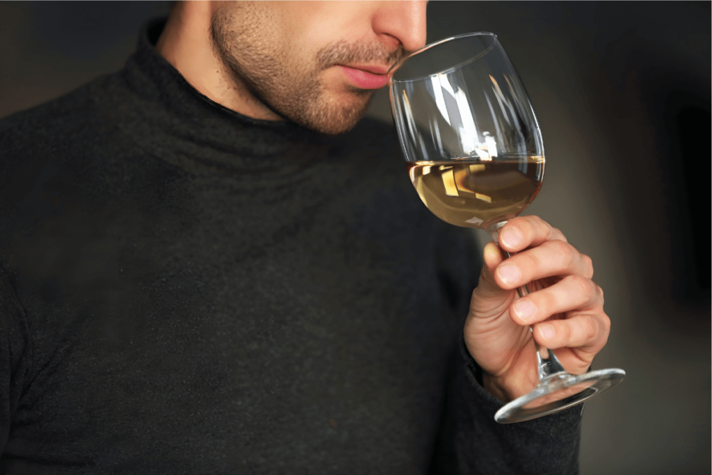Pessoa Cheirando Vinho Branco.
Vinho branco evite erros.