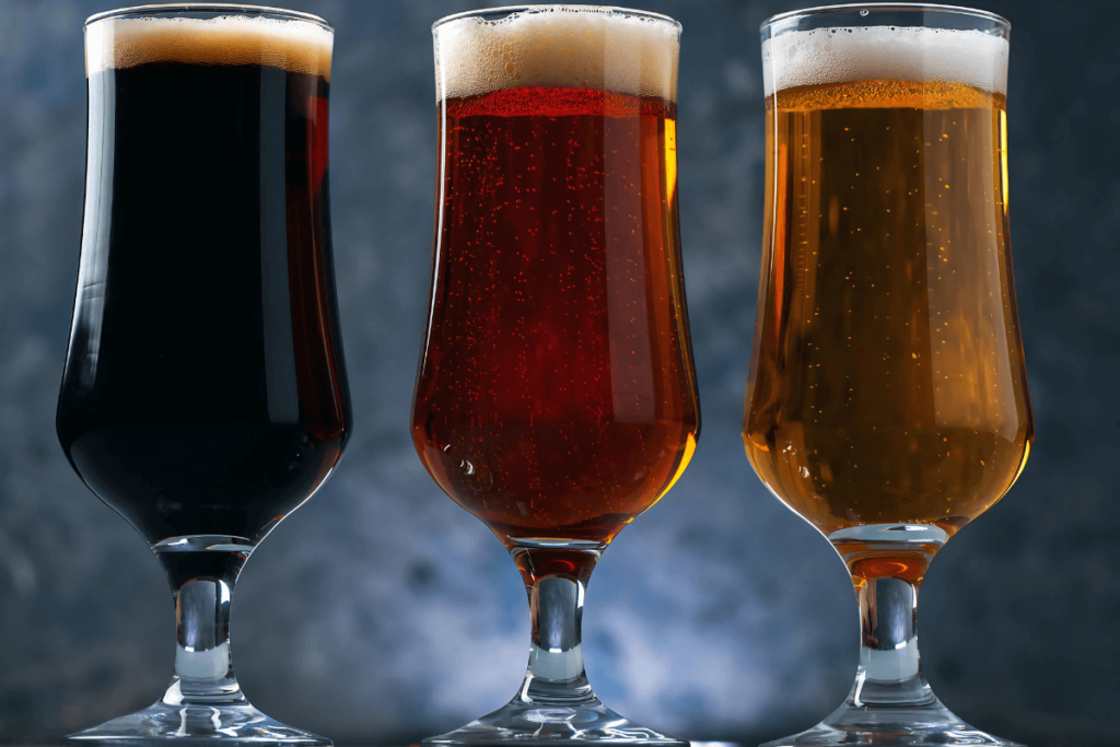 Três copos de cerveja. Diferentes estilos de cerveja, pilsner, lager, stout.
Guia Cervejas Artesanais.
